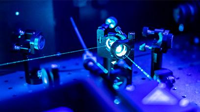 stock image of a laser reflecting through a lens