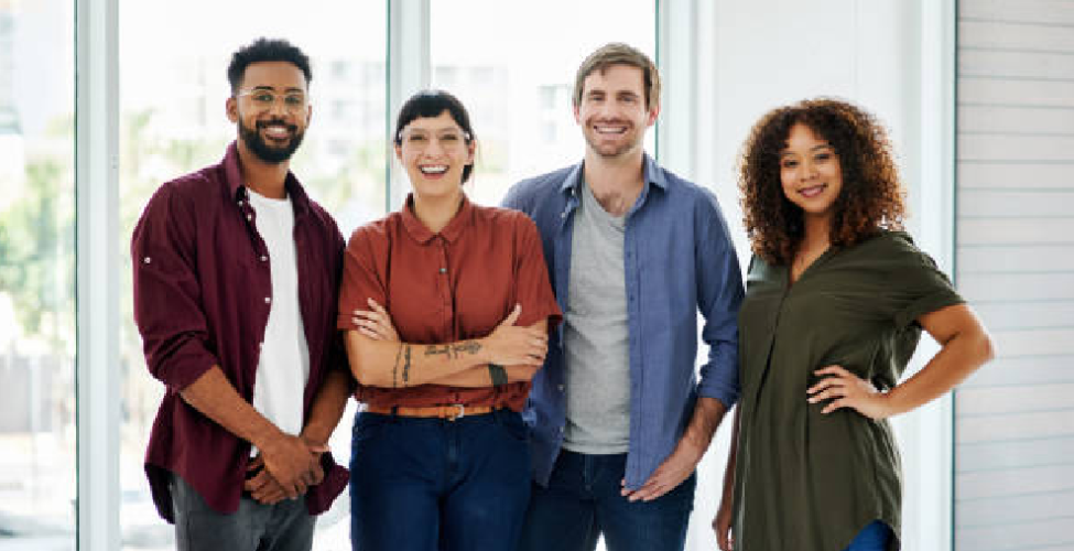 Diverse group of young professionals posing for a photo by a window