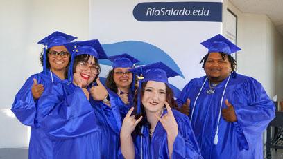 HSE graduates celebrate in front of a Rio Salado College banner