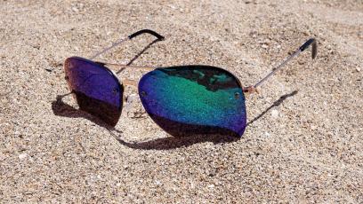 Pair of sunglasses lying in sand