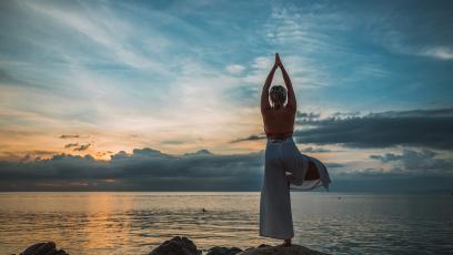 Woman doing a yoga pose by the seashore