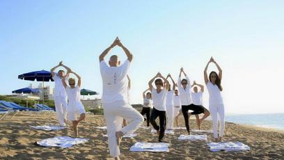 A group of people practicing yoga on the beach