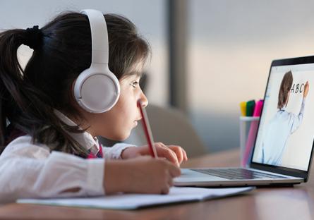 Elementary school student interacting with a teacher via laptop