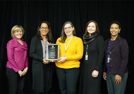 President Kate with Community Development directors and managers holding a plague