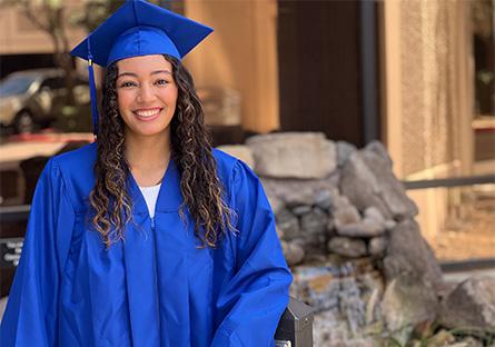 Alivia Proctor posing outside in a cap and gown