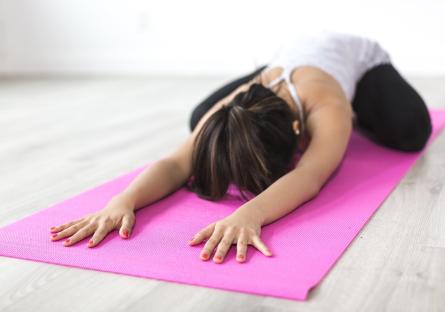 Woman doing yoga on a pink yoga mat
