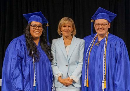 HSE graduate speakers Adriana Franco and Xander Westfall stand with President Kate Smith before the ceremony