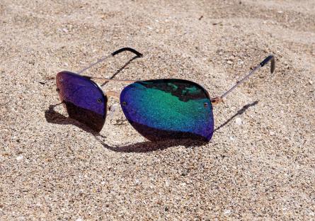 Pair of sunglasses lying in sand