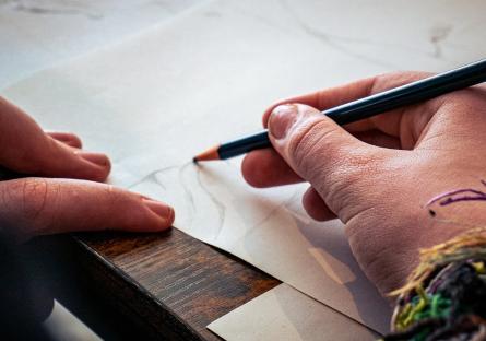 Hands drawing on a notebook