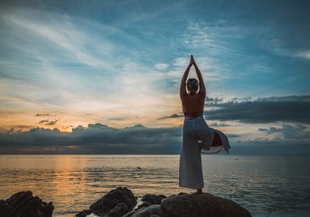 Woman doing a yoga pose by the seashore