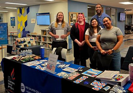 group of students and staff during a vote drive with various promotional materials on a table