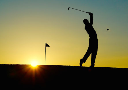 Silhouette of a man playing golf