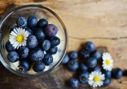 Blueberries in a bowl with daisies